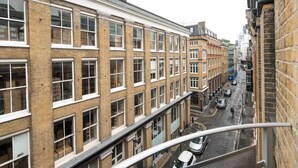 Un immeuble à plusieurs étages, avec une rangée de fenêtres et une rue en contrebas.