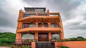 A multi-story building with a wooden facade, balconies, and a gated entrance. - Artisav House-A Luxury Boutique Stay (Amer)