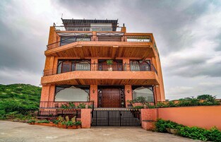 Un edificio de varios pisos con fachada de madera, balcones y una entrada protegida por una reja.