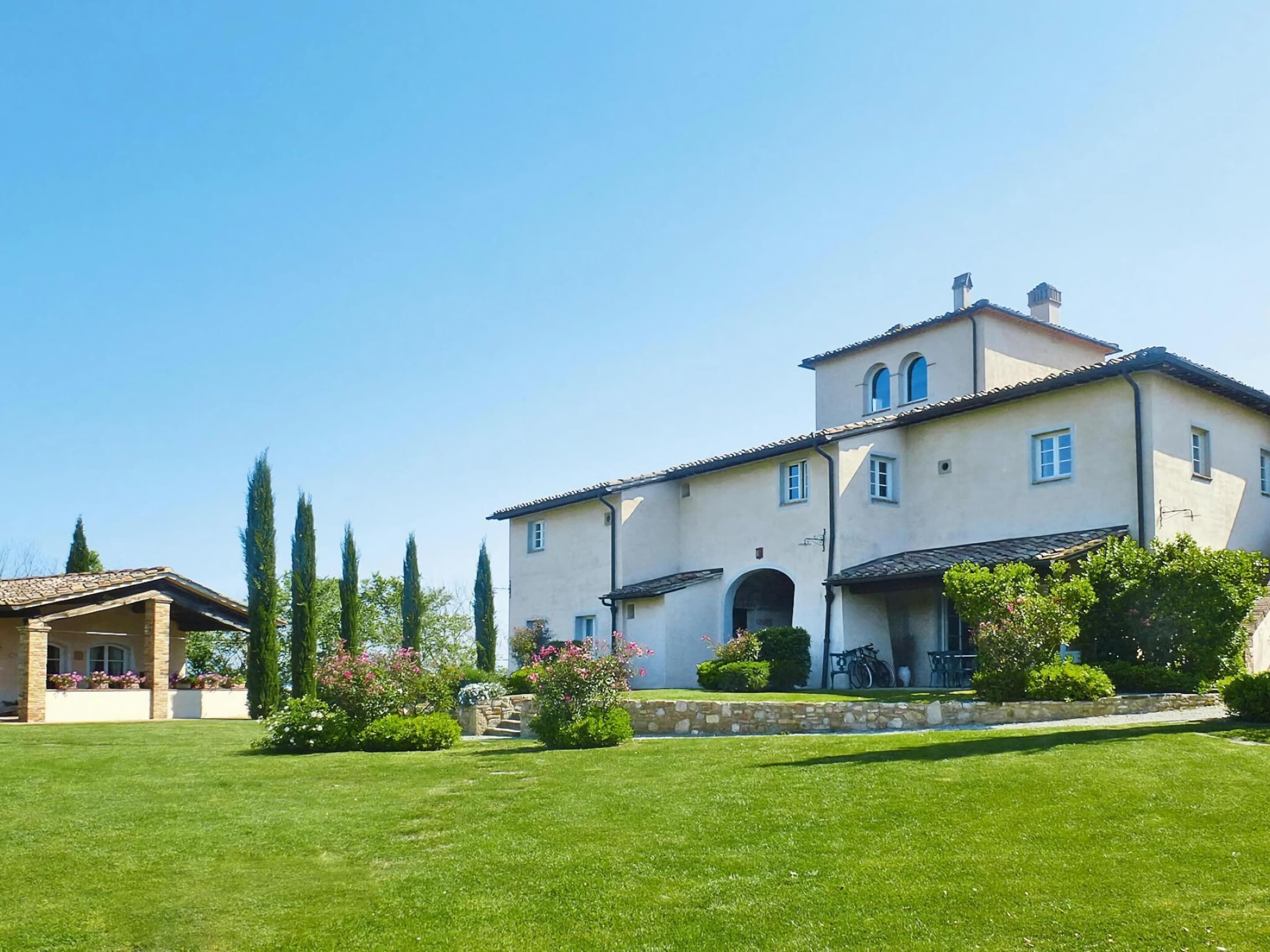 A large, two-story building with a symmetrical facade, arched windows, and a stone foundation.
