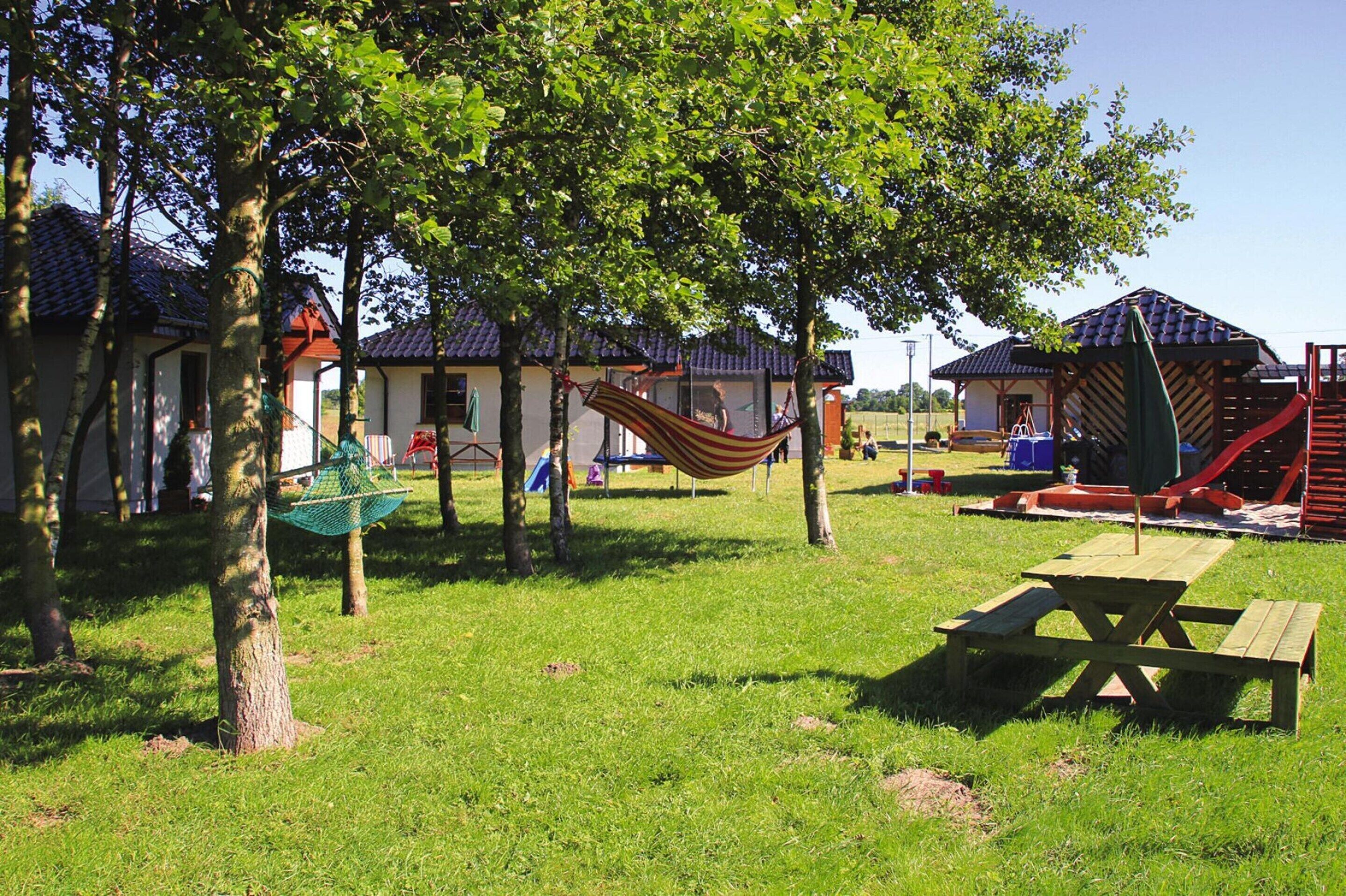 A playground with a slide, swings, and a picnic table.