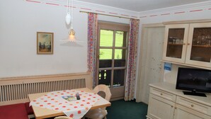 A dining area with a table, chairs, a television, and a cabinet. - Apartment in Krimml With Parking Space (Krimml)