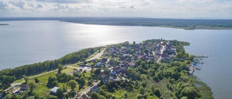 An aerial view of a lakeside village with houses, docks, and a clear sky.