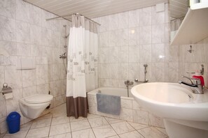 A bathroom with a toilet, bathtub, and sink. - Holiday Home in Busum in a Beautiful Area (Büsum)