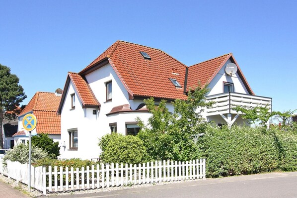 A two-story house with a red-tiled roof, white walls, and a white picket fence. - Holiday Home in Busum in a Beautiful Area (Büsum)