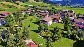 En landlig landsby med huse, grønne marker og en sø.