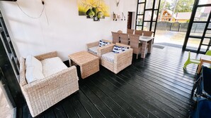 A cozy indoor seating area with wicker furniture, a painting on the wall, and a view of the outside. - Apartment in Jaroslawiec Near the Beach (Postomino)