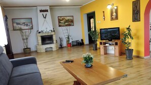 A living room with a fireplace, television, and potted plants. - Holiday Home in Stepnica for 6 Persons (Stepnica)