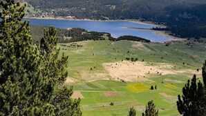 A mountainous landscape with a lake and forested areas. - Ferienwohnung, Graal-muritz (Graal Mueritz)