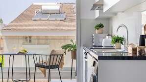 A modern kitchen with a built-in oven, a sink, and a dining area with a table and chairs. - Sanders Cruise Limassol (Limassol)