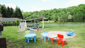 Un parc équipé de tables de pique-nique, d’un espace de repos abrité et d’un lac.
