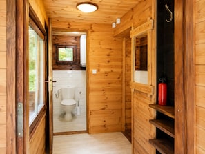 A wooden interior with a toilet, a window, and a fire extinguisher. - Holiday Home Right on the Lake, Natac Wielka (Nidzica)
