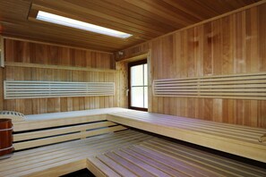 A sauna with wooden benches and a skylight.