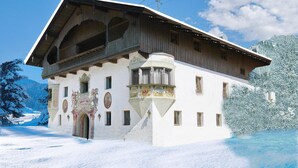 Ein traditionelles Chalet mit steilem Dach, hölzernen Balkonen und einer verzierten Fassade.