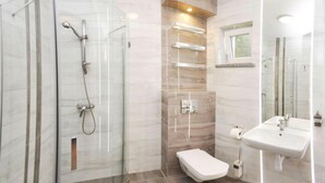 A modern bathroom with a glass-enclosed shower, a toilet, a sink, and a vanity with shelves. - Comfortable Holiday Homes by the Sea, Jaroslawiec (Postomino)