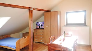 A small, cozy room with a loft bed, a wooden desk, a chair, and a television. - Agriculture - Studios, Borzyslawiec by Lubczyna (Goleniow)