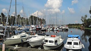 A marina with various boats docked, including sailboats and motorboats, under a clear sky. - Agriculture - Studios, Borzyslawiec by Lubczyna (Goleniow)