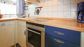 Eine Küche mit Backofen, Spüle und Kaffeemaschine.