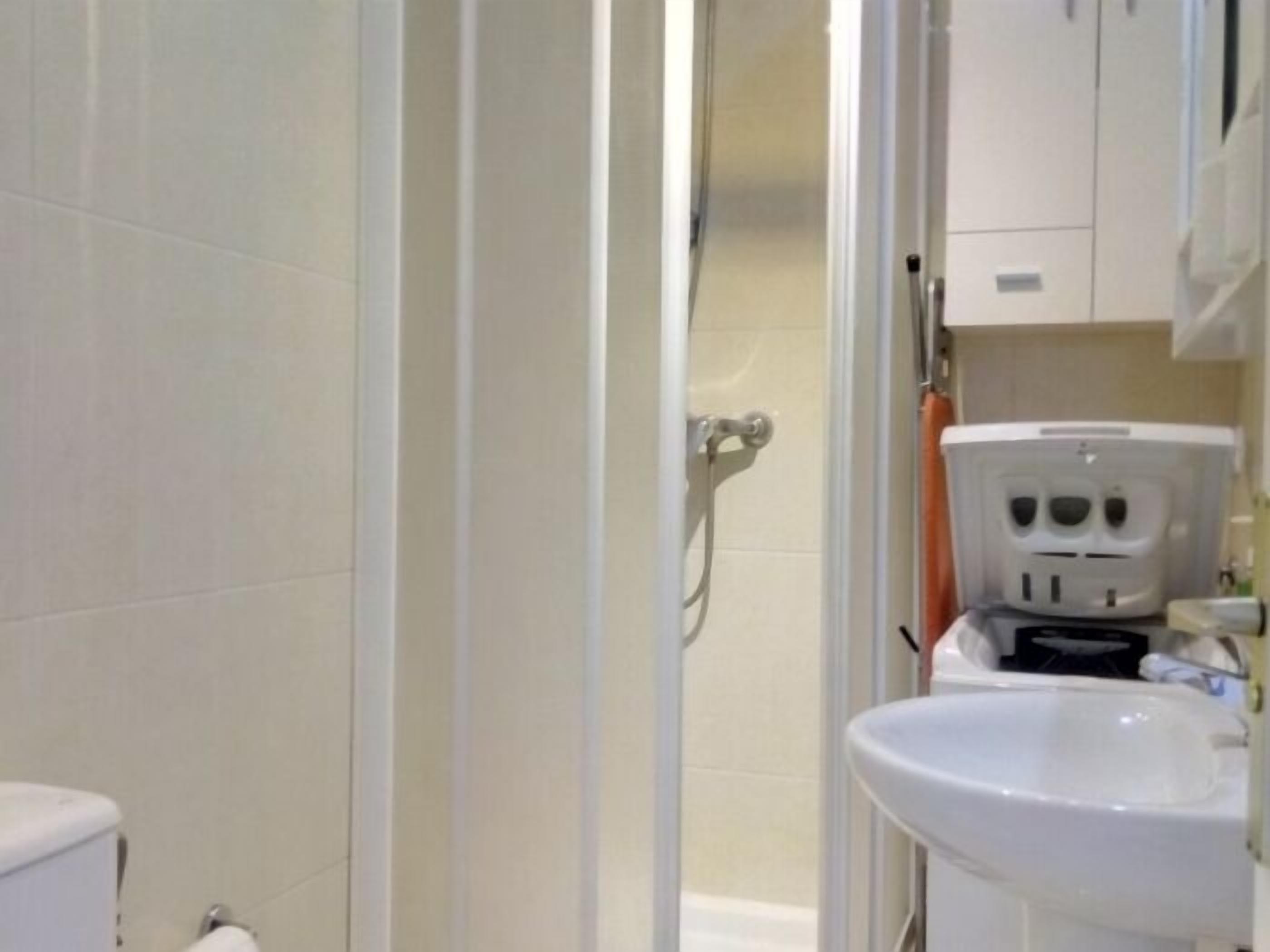 A bathroom with a toilet, sink, and shower.
