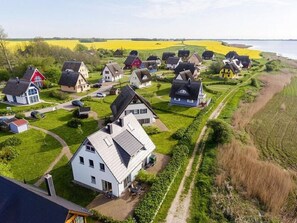 En landlig landsby med traditionelle huse, en tydelig sti og marker.