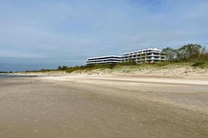 Ein Strandhotel mit mehreren Etagen, direkt am Sandstrand mit Blick aufs Meer.