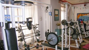 A gym with various weightlifting equipment, including barbells, weight plates, and benches. - Apartment in Garda Near Shopping (Garda)