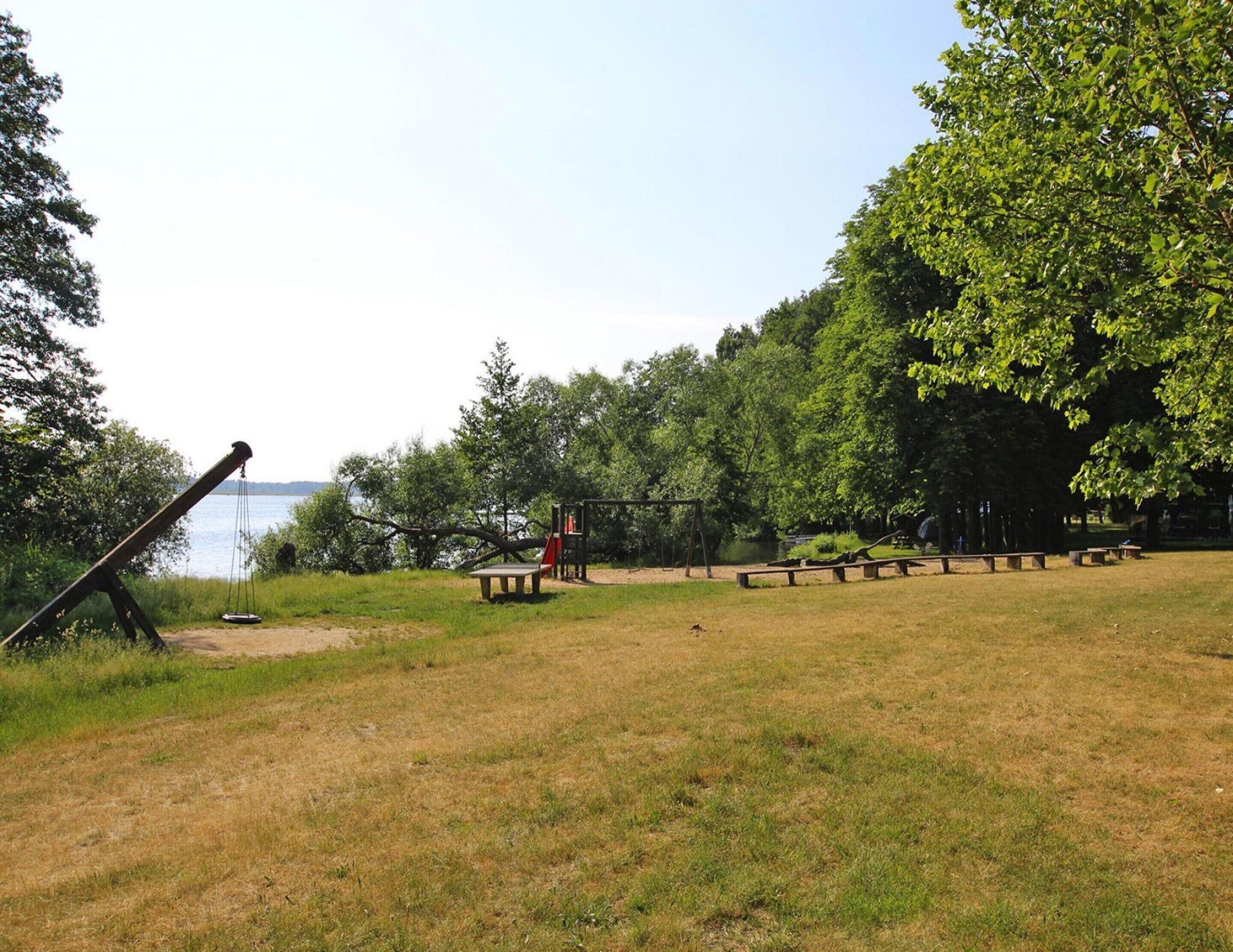 A park with a swing set, picnic tables, and a bench area.
