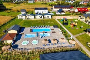 Zona residencial con piscina, varias casas y un parque infantil.