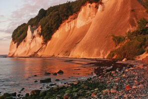A coastal landscape with cliffs and a rocky beach.