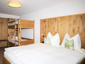 A bunk bed room with a wooden headboard, a bedside table, and a lamp. - Apartment in Bramberg Near Cable Car (Bramberg am Wildkogel)