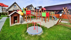 Une aire de jeux avec des balançoires, des structures d’escalade et un manège.