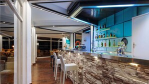 A bar area with a stone wall, bar stools, and a variety of bottles. - Jelsa Resort Apartment With Pool (Jelsa)