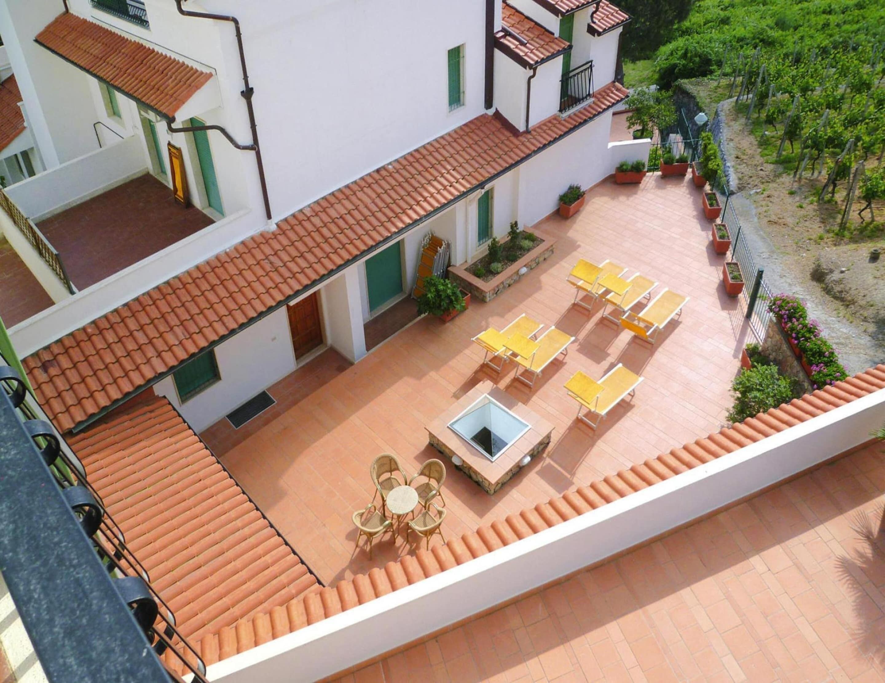 A courtyard with a tiled floor, outdoor seating, and a small table with chairs.
