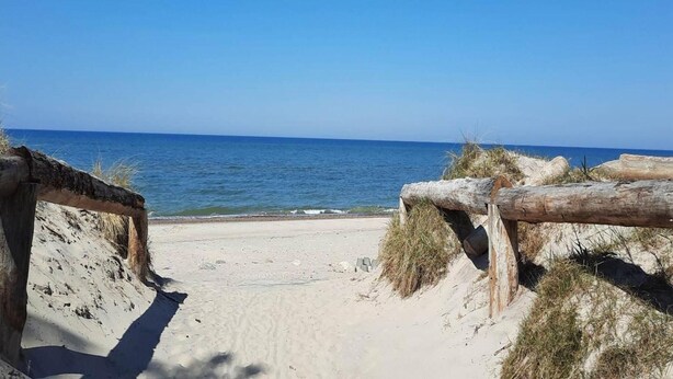 A sandy beach with a wooden fence leading to the sea. - Comfortable House With Private Garden, Rusinowo (Postomino)