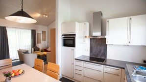 A modern kitchen with white cabinets, a black countertop, and a stainless steel sink. - Ferienhaus in Falkenstein (Falkenstein)