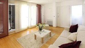 A modern living room with a white sofa, a coffee table, and a fluffy rug. - Apartments in Villas Punta Skala With Beachpool (Zadar)