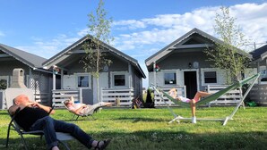 Una zona residenziale con due case, ciascuna dotata di un portico e un piccolo giardino.