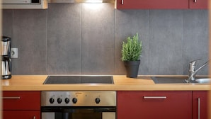 A modern kitchen with a built-in microwave, a stainless steel range hood, a sink with a modern faucet, and a small potted plant. - Apartment in Fugen Near Spieljoch Ski Lift (Fuegen)