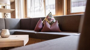 A modern living room with a grey sofa, a wooden coffee table, and decorative pillows. - Apartment in Fugen Near Spieljoch Ski Lift (Fuegen)