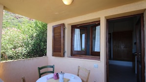 A small round table with chairs, a coffee pot, and a cup on a balcony with a view of greenery. - Terraced House With Communal Pool Costa Paradiso-formerly TUI Ferienhaus (Trinità d'Agultu e Vignola)