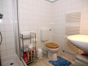 A bathroom with a shower, toilet, and sink. - Appartementhaus Kranichblick, Breege (Breege)