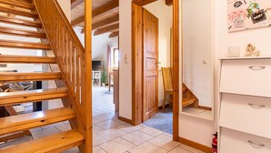 A wooden staircase leading to a living area with a white cabinet and a fire extinguisher. - Landhaus in Vollerwiek (Vollerwiek)