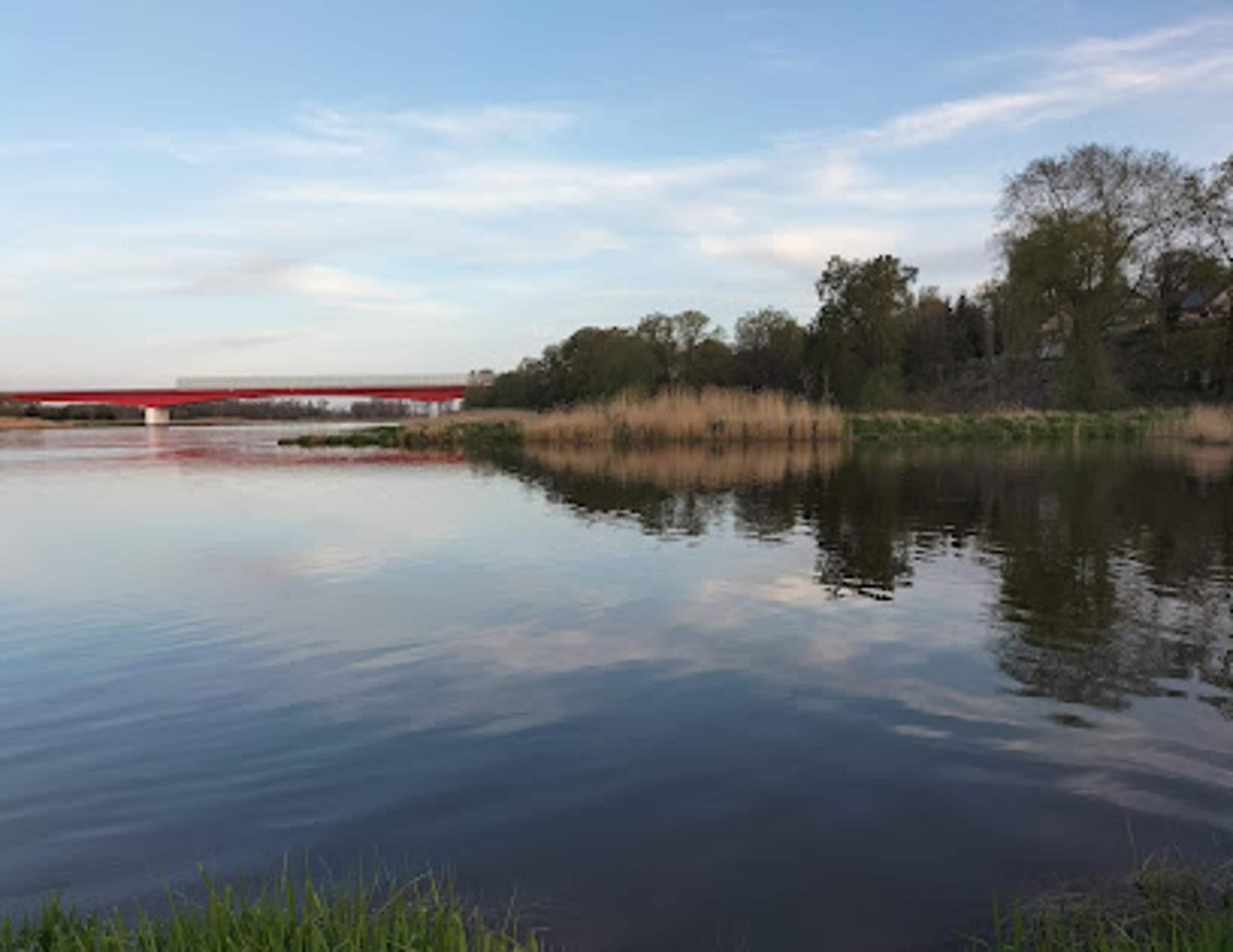 A calm river with a bridge in the background.