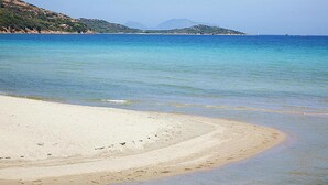 A beach with clear water and a sandy shore.