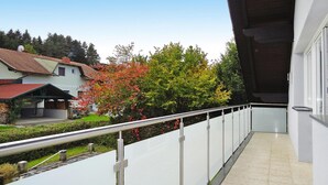 A balcony with a metal railing overlooking a residential area with houses and trees. - Apartment in St. Kanzian Near Klopeiner See (Sankt Kanzian am Klopeiner See)
