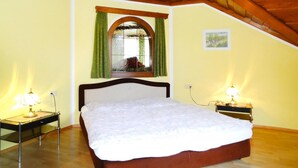 A bedroom with a bed, two bedside tables with lamps, a window with curtains, and a picture on the wall. - Apartment in St. Kanzian Near Klopeiner See (Sankt Kanzian am Klopeiner See)