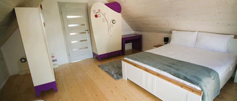 Una camera da letto con soffitto in legno, un letto con coperta grigia, un armadio bianco e una sedia viola.