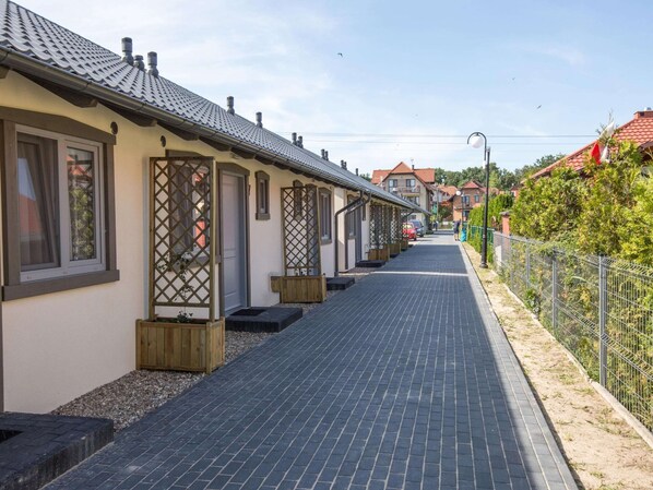 Traditional buildings line a serene, paved walkway, offering a peaceful retreat.
