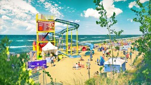 Ein Strand mit Wasserrutsche, Zelten und einem Restaurant.