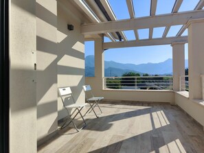 A balcony with a view of mountains, two white chairs, and a tiled floor. - Holiday Home Casa Simone in Lido (Camaiore)